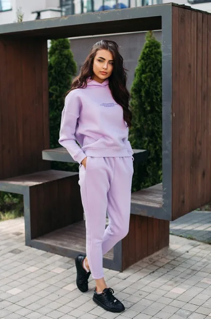 Women in lavender sweatshirt and joggers with black shoes