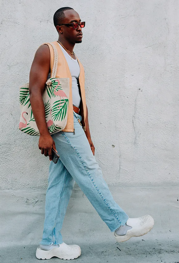 man in peach jacket carrying a cloth bag