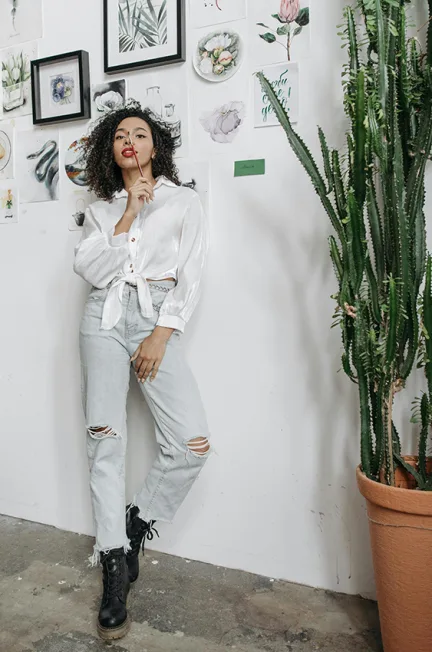 woman wearing white satin top and blue jeans
