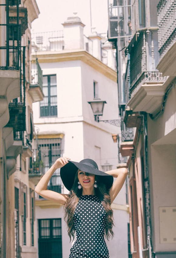 Woman wearing black polka dress and hata