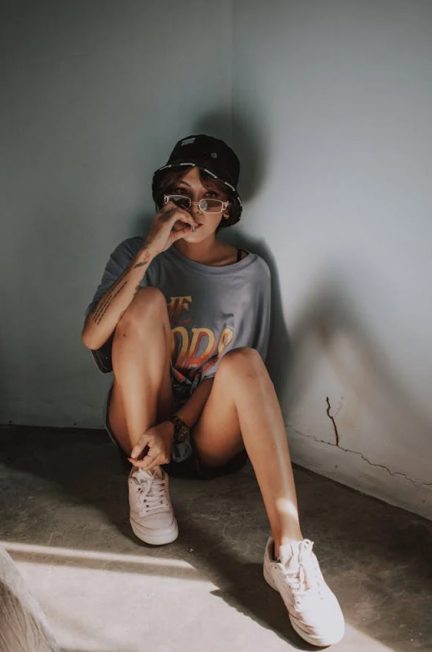 Woman wearing a hat,glass and white sneakers